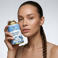 Woman holding a can of 'Valencia Bloom' against a gray background